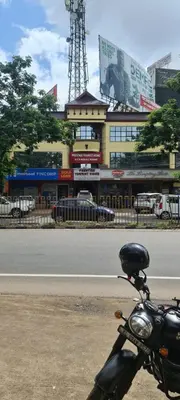 a motorcycle parked on the side of a street at Prestige Tourist Home in Nedumbassery