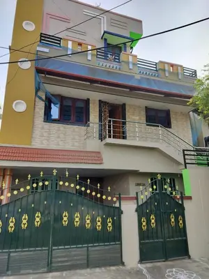 a house with a green gate in front of it at Honeycomb Homestay Ground Floor in Palani