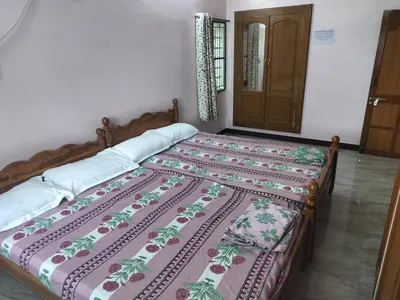 a bed in a room with a bedspread on it at Honeycomb Homestay Ground Floor in Palani