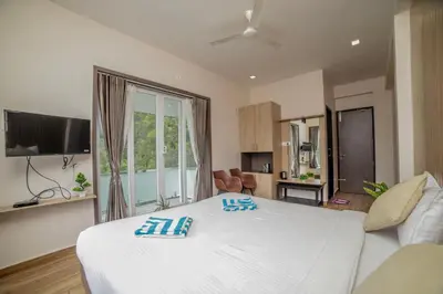 a bedroom with a large white bed and a large window at Abhinav Nest by Xplore Indo in Kodanād