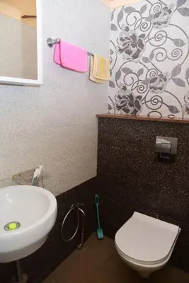 a bathroom with a white toilet and a sink at Ac 3 Bedroom House Mysore in Mysore