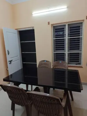 a black dining room table with chairs and windows at Ac 3 Bedroom House Mysore in Mysore