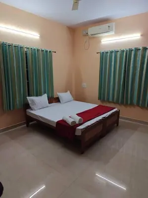 a bedroom with a large bed with green curtains at Ac 3 Bedroom House Mysore in Mysore