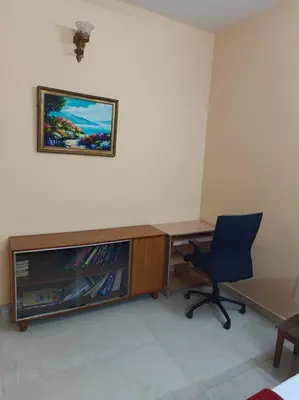 a desk with a television and a chair in a room at Ac 3 Bedroom House Mysore in Mysore