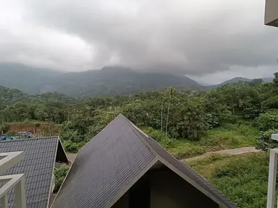 a roof of a house with a view of a mountain at Rains Valley Resort By Teal Luxury Stays in Viripara