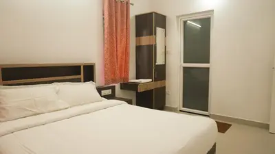 a bedroom with a white bed and a window at Rains Valley Resort By Teal Luxury Stays in Viripara