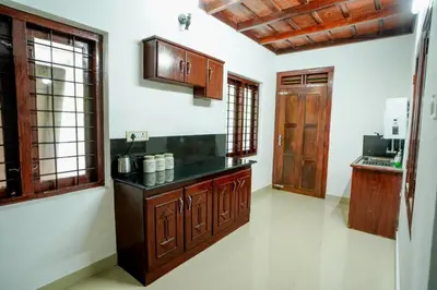a kitchen with wooden cabinets and a counter top at Wayanad Palm Grove Retreat 1st Floor in Wayanad