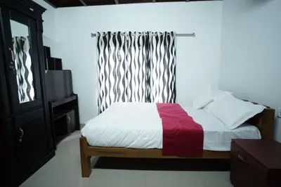 a bedroom with a bed with a red blanket and a window at Wayanad Palm Grove Retreat 1st Floor in Wayanad