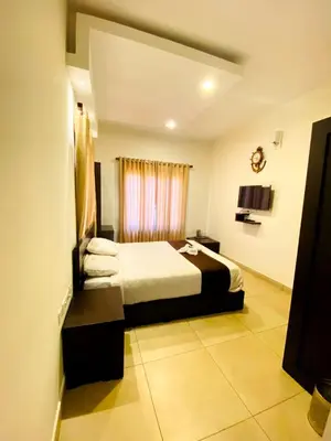 a hotel room with a bed and a window at Albis Ville Ooty in Ooty