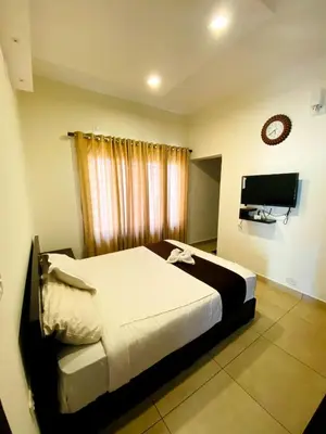 a bedroom with a bed and a flat screen tv at Albis Ville Ooty in Ooty