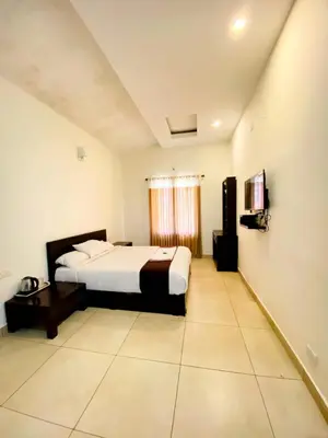 a hotel room with a bed and a television at Albis Ville Ooty in Ooty