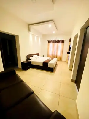 a hotel room with a bed and a couch at Albis Ville Ooty in Ooty