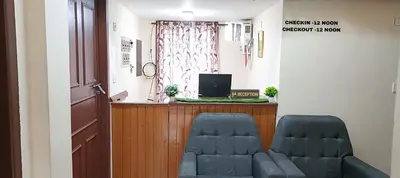 a room with two chairs and a desk with a computer at Swarna Tourist home Munnar in Munnar
