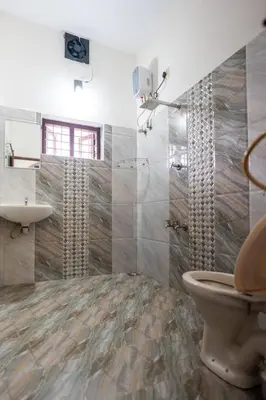 a bathroom with a toilet and a sink at Nest Villa - A Homely Heaven Near the Skies in Nedumbassery