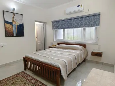 a bedroom with a large bed and a window at 7 Elysee Homestay - Lapis - Premium 3BHK Family Flat in Trichūr