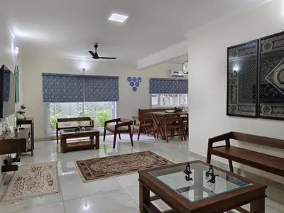 a living room with tables and chairs in a room at 7 Elysee Homestay - Lapis - Premium 3BHK Family Flat in Trichūr
