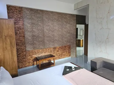 a bedroom with a bed and a wall at Yogis Stay in Kozhikode