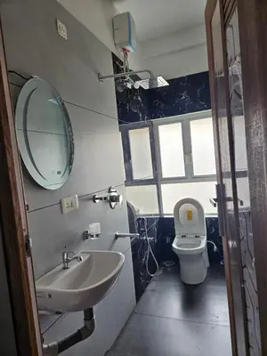 a bathroom with a sink and a mirror and a toilet at Yogis Stay in Kozhikode