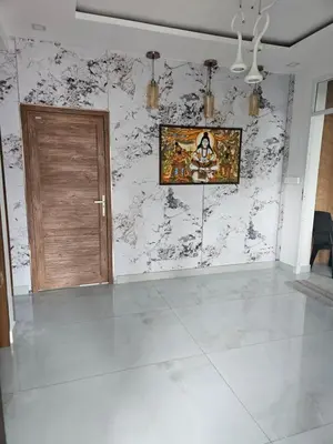 a room with a wooden door and a marble wall at Yogis Stay in Kozhikode