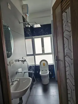 a bathroom with a toilet and a sink and a window at Yogis Stay in Kozhikode