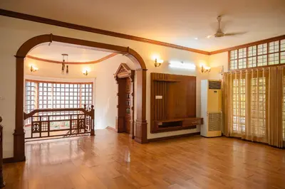 a living room with a wooden floor and a large doorway at Puzhayoram holiday home, Aluva in Alwaye