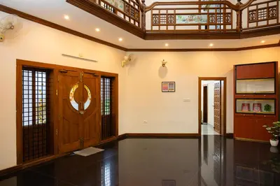 a hallway with a wooden door and a ceiling at Puzhayoram holiday home, Aluva in Alwaye