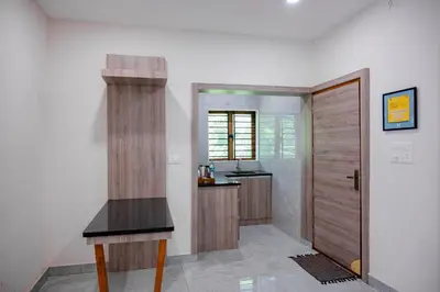 a kitchen with a counter and a sink and a door at Puzhayoram holiday home, Aluva in Alwaye