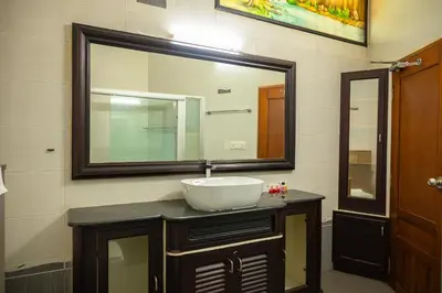 a bathroom with a sink and a large mirror at Puzhayoram holiday home, Aluva in Alwaye