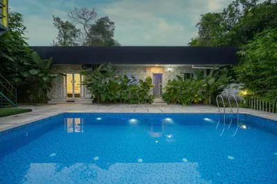 a swimming pool in front of a house at River Serene Holiday home in Kizhake Chālakudi