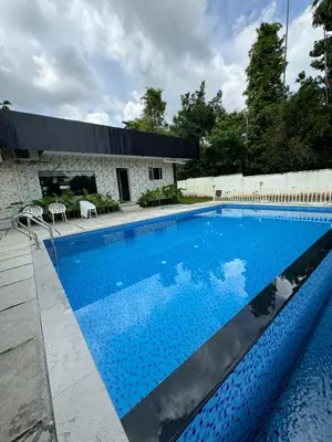 a swimming pool with blue water in front of a building at River Serene Holiday home in Kizhake Chālakudi