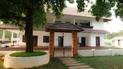 a house with a gate and a tree at Tamarind Heritage Holiday Home in Angamali