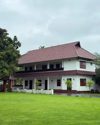 a house with a green lawn in front of it at Tamarind Heritage Holiday Home in Angamali