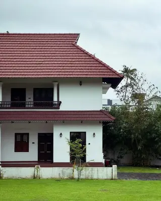 a white house with a red roof at Tamarind Heritage Holiday Home in Angamali