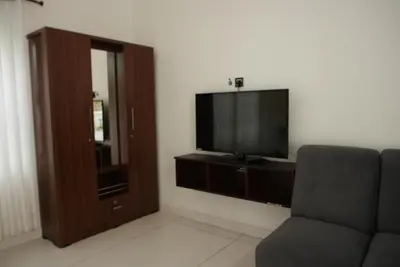 a living room with a couch and a flat screen tv at Tamarind Heritage Holiday Home in Angamali