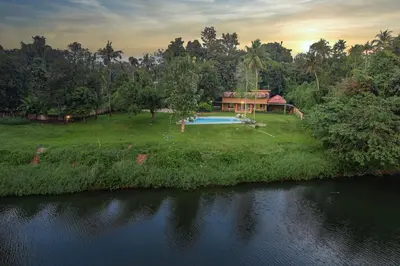 a house with a swimming pool in the middle of a river at Theeram Riverside Holiday Home in Māla