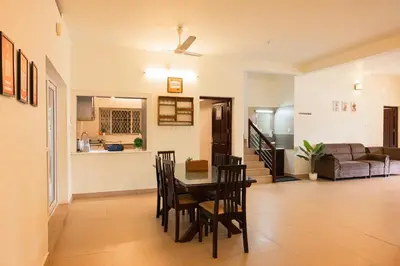 a dining room and living room with a table and chairs at Theeram Riverside Holiday Home in Māla