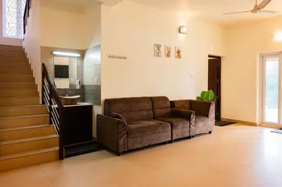 a living room with a couch and a staircase at Theeram Riverside Holiday Home in Māla
