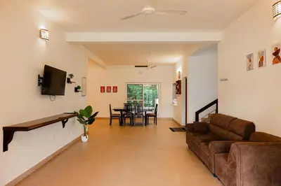 a living room with a couch and a table at Theeram Riverside Holiday Home in Māla