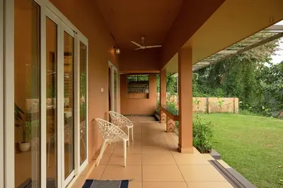 a porch of a house with two chairs at Theeram Riverside Holiday Home in Māla
