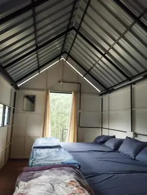 a bedroom with two beds and a window at Hazy Mount Vattavada in Kottakamboor