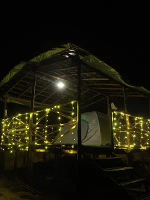 a tent covered in lights in the dark at Hazy Mount Vattavada in Kottakamboor