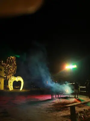a group of people standing in front of a lighted arch at night at Hazy Mount Vattavada in Kottakamboor
