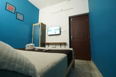 a hotel room with a bed and a television at Twinn Waves By Atmos in Kozhikode