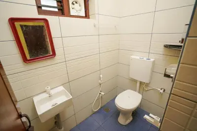 a small bathroom with a toilet and a sink at Twinn Waves By Atmos in Kozhikode