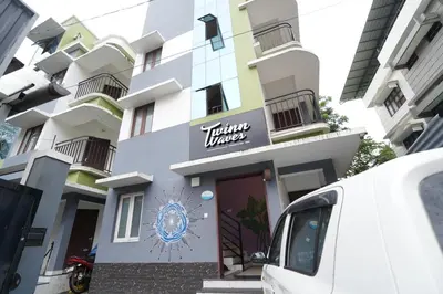 a white van parked in front of a building at Twinn Waves By Atmos in Kozhikode