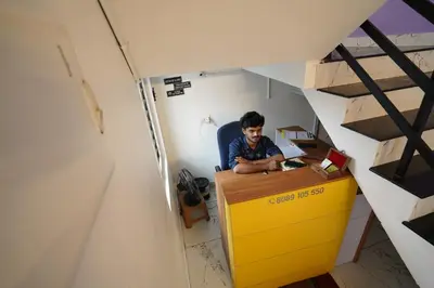 a man sitting at a desk in a room at Twinn Waves By Atmos in Kozhikode