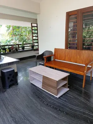 a room with a wooden bench and a table at Shruthi's Aarohi-Nature's Retreat Homestay in Kannur