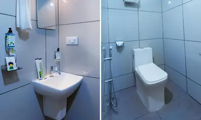 a white bathroom with a toilet and a sink at Treebo Airsuite Airport Hotel in Cochin