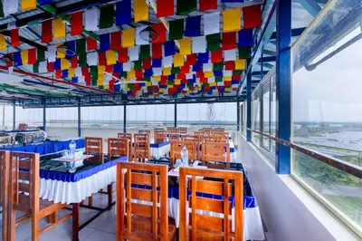a restaurant with tables and chairs under a colorful ceiling at Treebo Airsuite Airport Hotel in Cochin