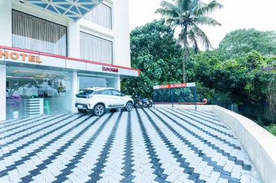 a car parked in a parking lot in front of a hotel at Treebo Airsuite Airport Hotel in Cochin